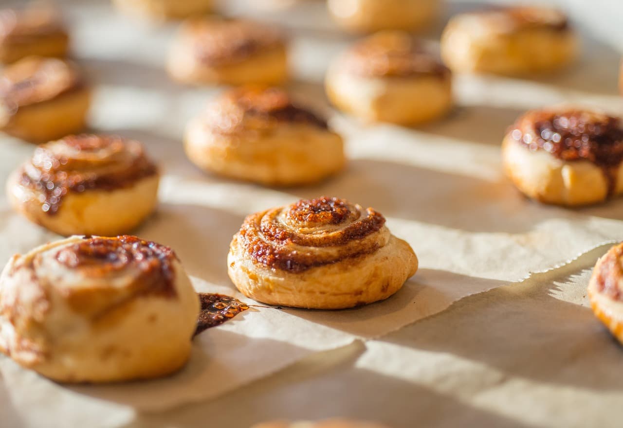 Cinnamon buns cooling on baking paper